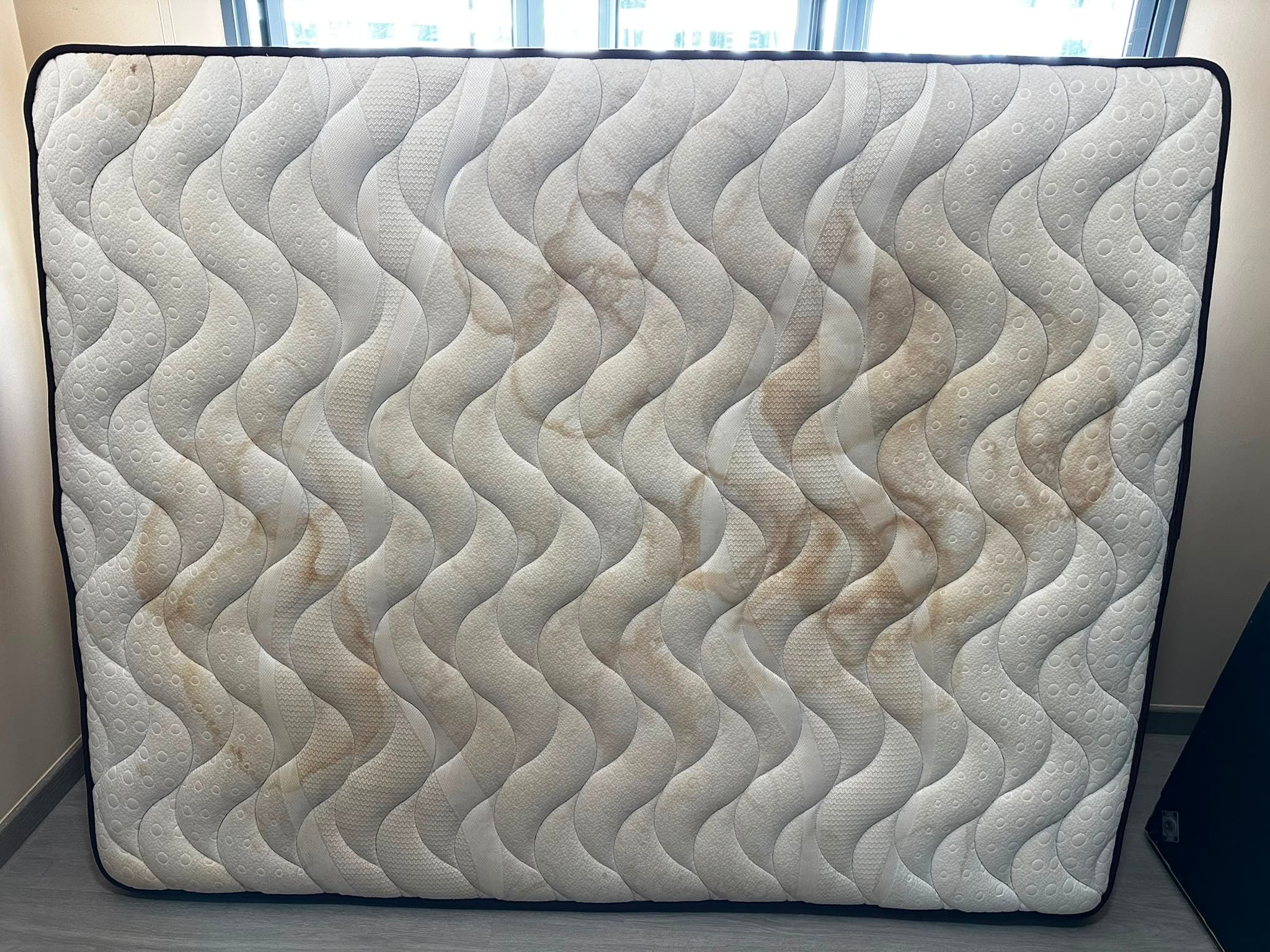 Mattress before cleaning, with visible stains and discolouration
